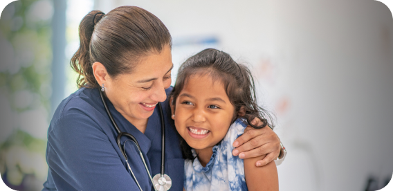 Enfermera abrazando a una niña sonriendo; logo de Fundación UC CHRISTUS