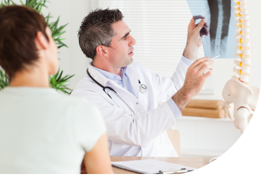 Traumatólogo en consulta revisando radiografia de de columna vertebral