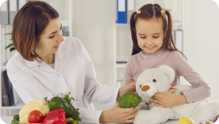 Nutrióloga infantil educando sobre nutrición a paciente pediátrico a través del juego