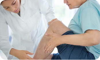 Cirujana vascular periférica revisando las várices a un paciente